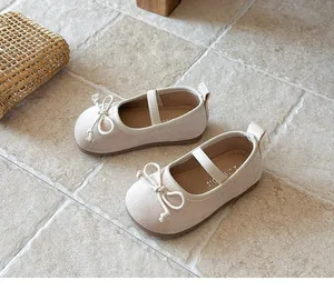 Vista detallada de zapatos Mary Jane de ante beige para niña con lazo decorativo y correa.