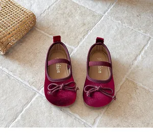 Detalle de zapatos Mary Jane de terciopelo burdeos para niña con un lindo lazo decorativo