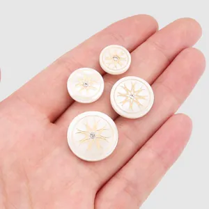Premium white mother of pearl buttons with gold starburst pattern and center crystal