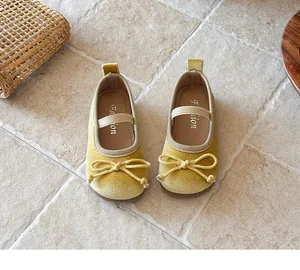Detalle de merceditas de terciopelo amarillo para niña con lazo y correa elástica suave