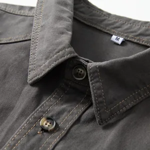 Detailed view of grey men's cotton denim shirt collar with button and size tag