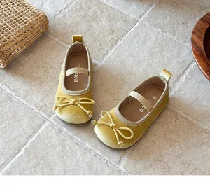 Detalle de zapatos Mary Jane de terciopelo amarillo para niñas con diseño de lazo