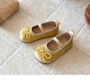 Vista detallada de zapatos Mary Jane de terciopelo amarillo para niñas con lazo y suela blanda