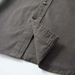 Detailed macro view showing the high-quality stitching and fabric texture of gray denim shirt