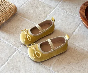Primer plano de los zapatos Mary Jane de terciopelo amarillo para niña con un lazo