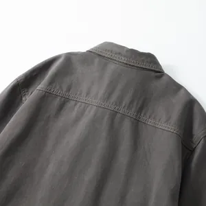 Close-up of men's dark grey cotton denim shirt showing back yoke and contrast stitching.