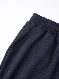 Dettaglio macro del tessuto a nido d'ape traspirante e tasca laterale su pantaloncini blu navy