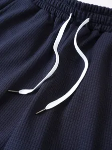 Primo piano di pantaloncini da mare da uomo in maglia a nido d'ape blu con cordino.