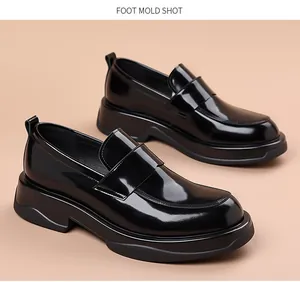 Vista detallada de elegantes mocasines negros brillantes para hombre con suelas de plataforma.