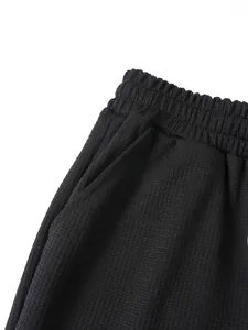Primo piano dei pantaloncini neri da uomo in maglia a nido d'ape con tessuto a trama.