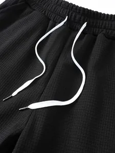 Dettaglio del tessuto traspirante a nido d'ape nero degli shorts da spiaggia da uomo