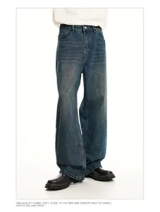 Detailed view of men's distressed vintage loose straight denim jeans in washed blue finish