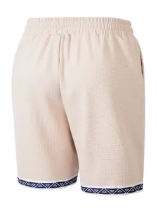 Dettaglio pantaloncini uomo in maglia a nido d'ape beige con bordo etnico geometrico