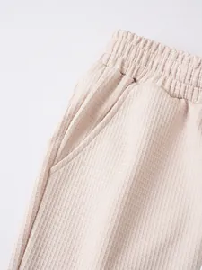 Primo piano dettagliato del tessuto a nido d'ape beige di questi pantaloncini da uomo