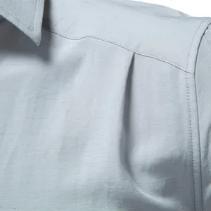 Detailaufnahme eines hellblauen Herren-Businesshemds aus strukturiertem Knitterstoff.