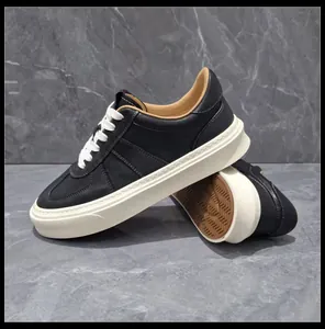 Close-up of men's black leather sneakers with thick off-white soles and white laces