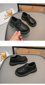 Vista dettagliata delle scarpe in pelle nera per bambini con velcro e suole spesse