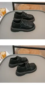 Dettaglio delle scarpe in pelle nera per bambini stile britannico con cinturino