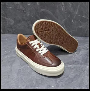 Detail view of men's brown leather sneakers showing the side profile and textured sole