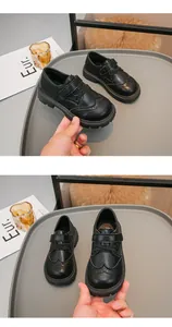Dettaglio scarpe Oxford nere per bambini con classici fori Brogue e chiusura a strappo