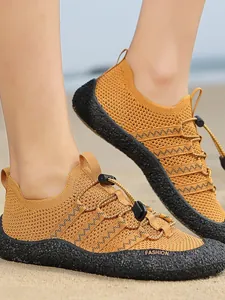 Zapatillas de playa transpirables de malla amarilla para hombre en una playa de arena