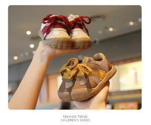 Close-up of mesh baby walker shoes with soft rubber soles in red and brown colors.