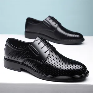 Chaussures de ville respirantes en cuir noir pour hommes avec design perforé en studio.