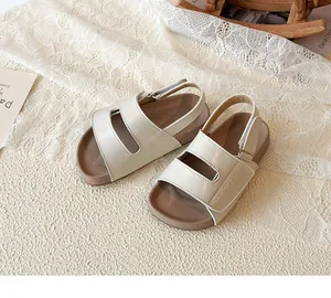 Detaillierte Nahaufnahme cremefarbener Kindersandalen mit weicher brauner Gummisohle