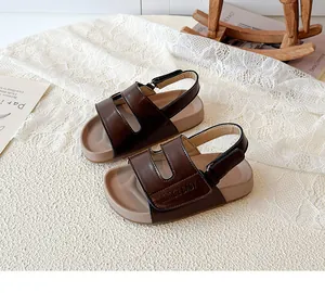 Detailaufnahme von braunen Kinderledersandalen mit Klettverschluss und rutschfesten Sohlen.