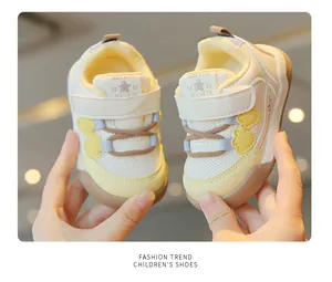 Close-up of breathable mesh toddler sneakers with yellow accents and soft soles.
