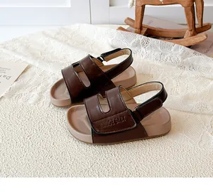 Nahaufnahme von braunen Kinder-Sandalen mit verstellbaren Riemen und weichen beige Sohlen.