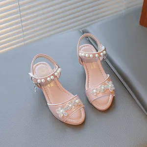 Detailed view of pink girl's princess sandals decorated with rhinestone flowers and pearls