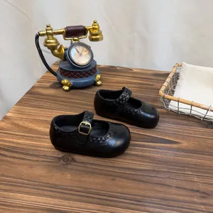 Retro schwarze Kinder Mary Jane Lederschuhe mit Vintage Requisiten in Detailansicht