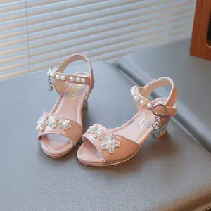 Detailed view of pink girls' sandals with rhinestone flowers and pearl straps.