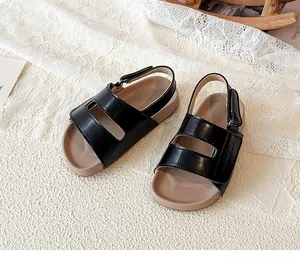 Detailansicht schwarzer Kindersandalen mit verstellbaren Riemen und brauner Sohle