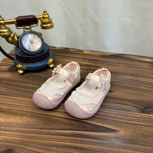 Detailed view of pink princess mesh sandals for girls with bow and pearl accents.