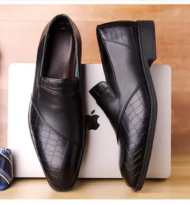 Detailweergave van zwarte herenloafers met krokodillentextuur en gepolijst.
