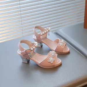 Macro detail of pink girl's princess sandals with sparkling rhinestone flowers and pearls