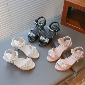 Three colors of girls' rhinestone flower sandals with pearl straps on grey bench
