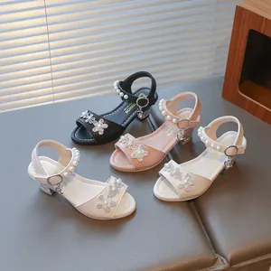 Detail view of girls' sparkling rhinestone flower sandals with pearl straps and block heels