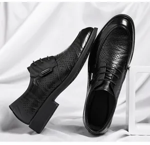 Detailed view of men's black perforated leather dress shoes for business attire.