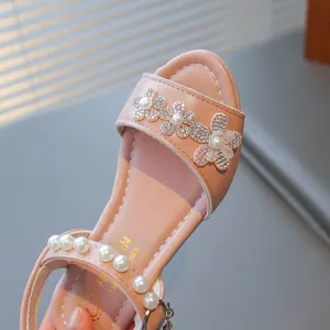 Close-up of pink girls princess sandals with rhinestone flowers and pearl straps