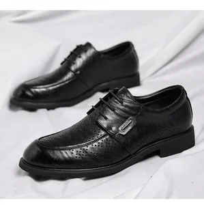Macro view of black leather dress shoes with hand-brushed texture and brogue details