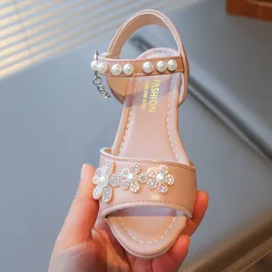 Close-up of pink girls princess sandal with rhinestone flowers and pearl strap