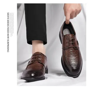 Detail view of brown perforated leather dress shoes for men with retro texture