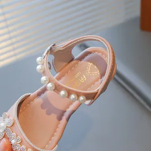Detailed view of pink girls' princess sandal featuring pearls and rhinestone flowers
