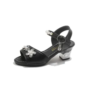 Detail view of black girls' high heel sandals with rhinestone flowers and pearls