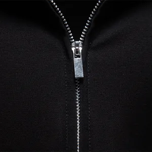 Detail view of the silver metal zipper on a black men's business casual Polo shirt