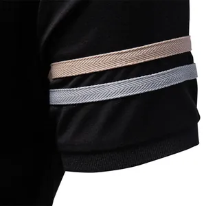 Close-up of men's polo shirt sleeve with stylish beige and grey herringbone stripes.