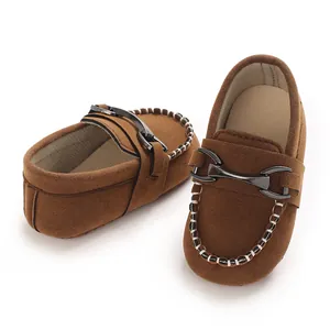 Close-up of brown suede baby loafers featuring a classic metal horsebit buckle